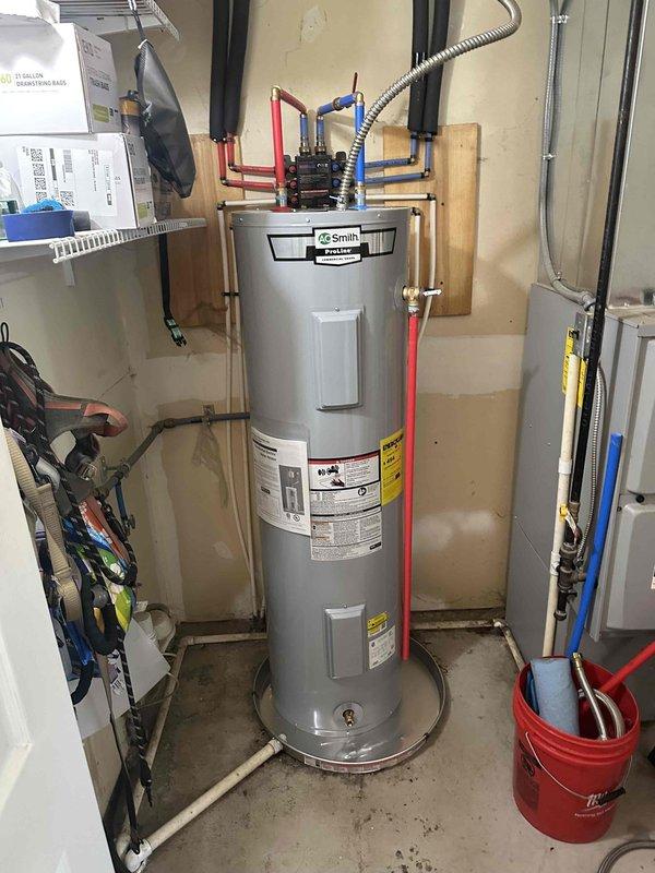 Completed installation of 40-gallon AO Smith ProLine commercial grade water heater at residential property. Installed new unit with professional plumbing manifold system featuring multiple PEX connections, brass fittings, and proper shut-off valves. Applied foam pipe insulation to water lines and ensured all connections were secure and code-compliant.