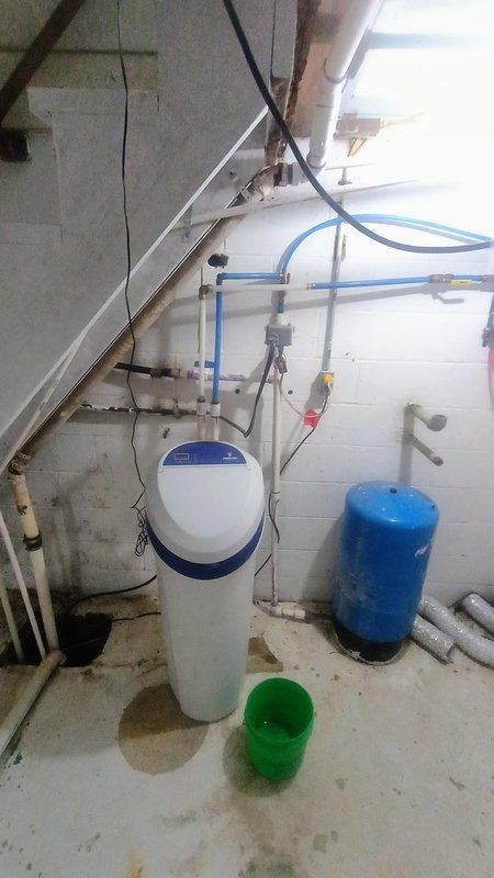 Installed 40-gallon electric water heater in basement utility alcove and reinstalled water softener system with proper connections. Completed plumbing connections between water heater, softener tank, and blue pressure tank, ensuring all components were properly integrated into the existing system. Provided quote for potential re-piping configuration to route all water through softener except exterior sill faucets.