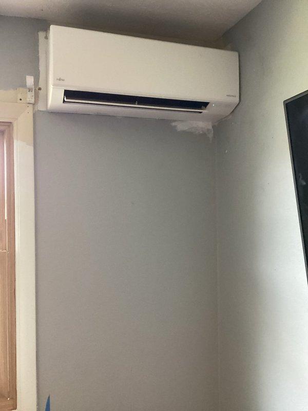 Installed a new Fujitsu ductless mini-split system in room 109, including indoor wall-mounted air handler positioned near ceiling and outdoor condensing unit on concrete pad against brick exterior. System fully operational with electrical connections, refrigerant lines, and condensate drain properly installed per manufacturer specifications.