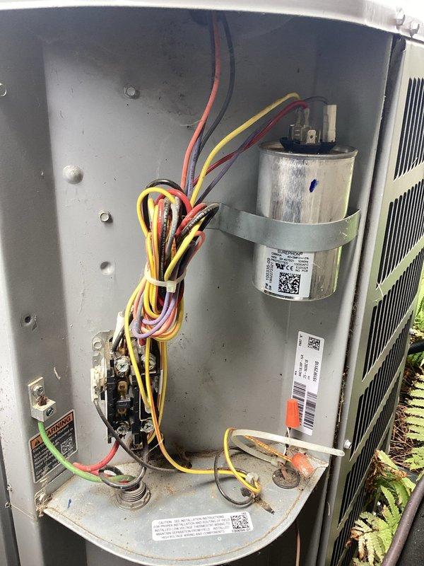 Completed planned maintenance on outdoor HVAC cooling unit, performing comprehensive inspection of electrical and mechanical components. Accessed interior compartment to verify proper operation of capacitor, contactor assembly, and all associated wiring connections, documenting system condition with photographic evidence for maintenance records.