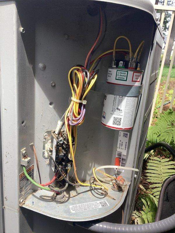 Completed planned maintenance on outdoor HVAC cooling unit, performing comprehensive inspection of electrical and mechanical components. Accessed interior compartment to verify proper operation of capacitor, contactor assembly, and all associated wiring connections, documenting system condition with photographic evidence for maintenance records.