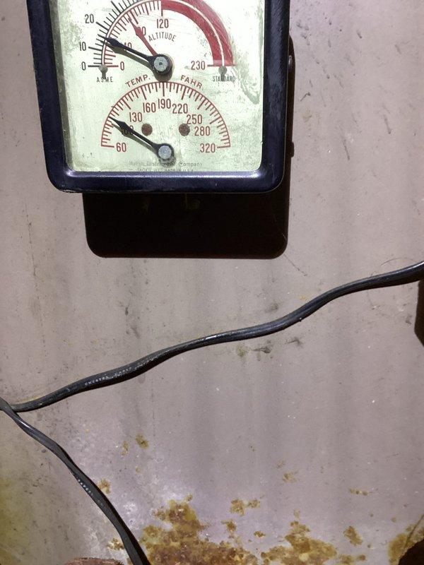 Responded to service call for boiler system discharging water from pressure relief valve during operation. Upon arrival, inspected boiler system and associated components including circulator pump, pressure gauge, and relief valve assembly. Found circulator pump showing significant wear and age-related deterioration with paint loss exposing bare metal. Verified system pressure readings on wall-mounted gauge indicating potential overpressure condition. Documented existing conditions with photographs showing worn red circulator pump with copper piping connections displaying corrosion and oxidation, collection bucket positioned beneath unit to catch discharge. Assessed that pressure relief valve activation likely caused by circulation failure or expansion tank malfunction leading to excessive system pressure. Provided diagnostic findings to customer and discussed options for repair versus replacement. Customer requested quote for new boiler system installation as alternative to repairing 