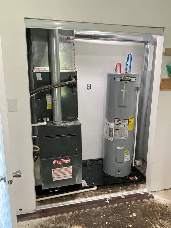 Reinstalled Goodman furnace and evaporator coil with new drain pan in mechanical closet, utilizing furnished risers to properly position equipment. Strategically placed drain pan to provide protection for furnace, water heater, and water softener. Routed overflow drain line from pan to existing sump basin in basement to ensure proper condensate management and prevent water damage.