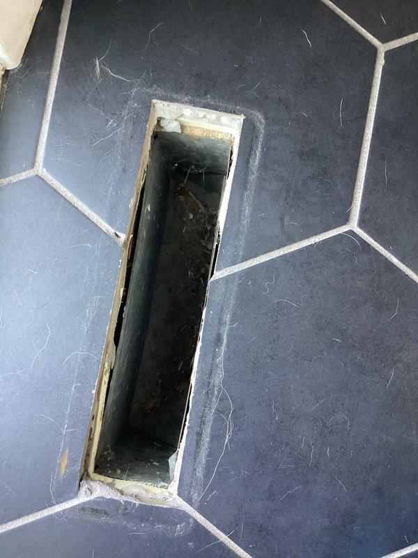 Completed comprehensive duct cleaning service for residential HVAC system. Accessed and cleaned floor register vents in multiple areas, including hexagonal tile flooring and laminate wood flooring locations, removing accumulated dust, debris, and contaminants from ductwork and register openings. Documentation photos captured pre-service conditions showing visible dust accumulation and debris within floor vent cavities and metal ductwork channels.