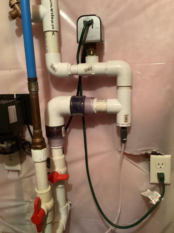 Responded to water leak in basement plumbing system serving sprinkler lines in 19-year-old residence. Located leak in PVC piping assembly and performed repair work on the affected section. Installed protective plastic sheeting over work area to contain moisture and debris during repair process. Repaired compromised PVC pipe connections in the main distribution manifold, which included multiple ball valves and pump assembly. Verified system integrity, tested all connections for proper sealing, and confirmed no additional leaks present throughout the sprinkler supply system.