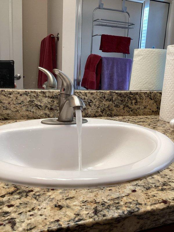Responded to callback for low water flow issue at bathroom faucet. Removed and inspected faucet aerator, which showed significant sediment buildup and debris causing restricted flow. Initial troubleshooting indicated either clogged cartridges or aerators as the source of the problem. Service was interrupted and rescheduled to complete diagnosis and repair, as specialized Delta faucet aerator removal tool is required to properly access and service the internal components.