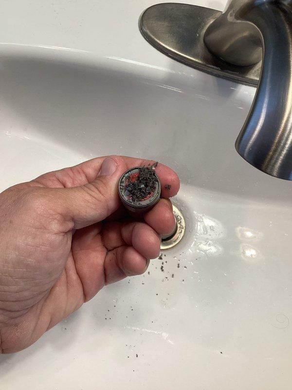 Responded to callback for low water flow issue at bathroom faucet. Removed and inspected faucet aerator, which showed significant sediment buildup and debris causing restricted flow. Initial troubleshooting indicated either clogged cartridges or aerators as the source of the problem. Service was interrupted and rescheduled to complete diagnosis and repair, as specialized Delta faucet aerator removal tool is required to properly access and service the internal components.