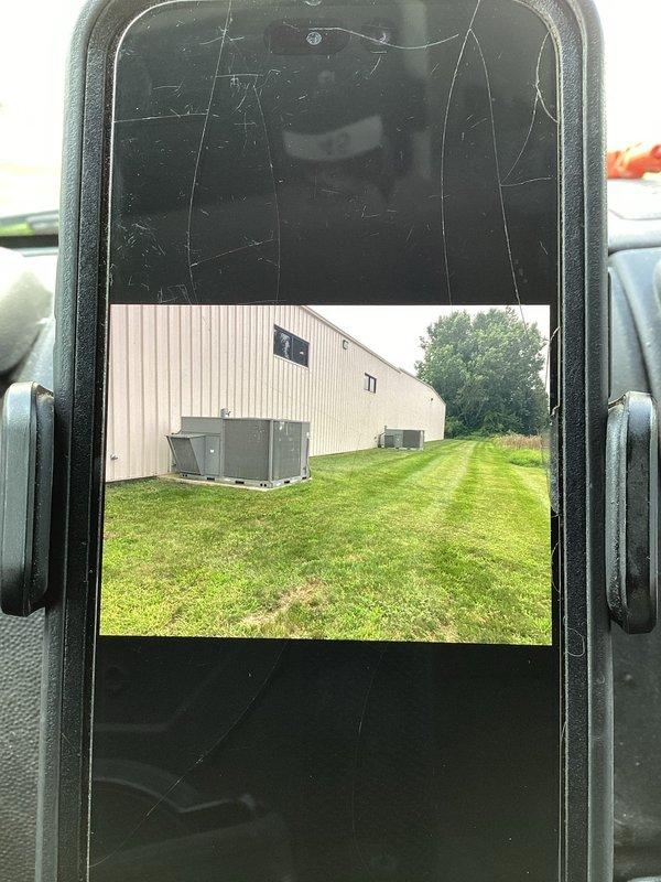 Responded to service call for two ground-level commercial HVAC units at light industrial facility. Performed diagnostic evaluation on first unit to assess repair versus replacement options due to reported operational failure. Investigated second unit experiencing thermostat control malfunction causing system to switch from cooling mode to heating mode during operation. Documented equipment conditions and locations with photographic records for assessment and recommendation purposes.