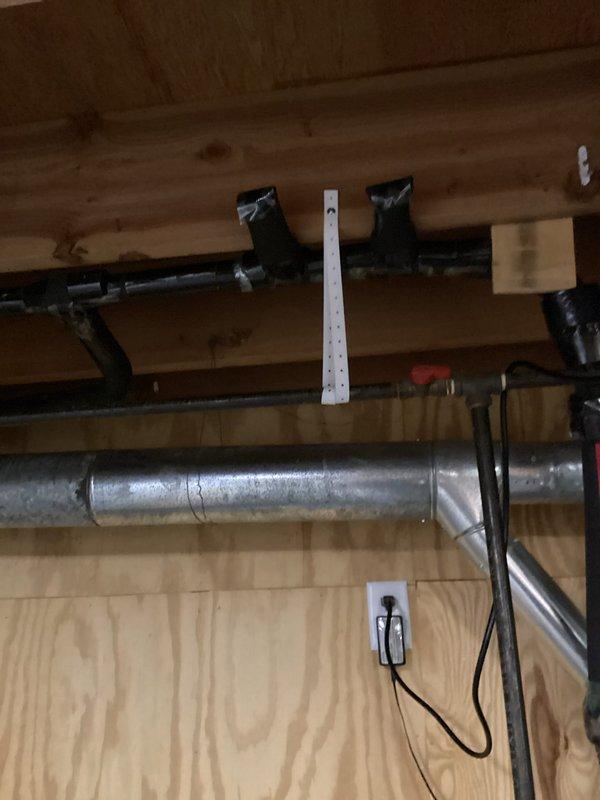 Performed inspection of basement gas piping that requires relocation to accommodate egress window installation. Assessed approximately 3-foot section of gas pipe currently routed through area designated for window opening, documented existing pipe configuration running along ceiling joists near HVAC ductwork and electrical systems, and evaluated scope of work required to safely reroute gas line to maintain code compliance while clearing egress window path.