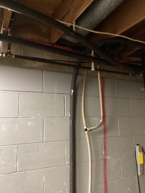 Performed inspection of basement gas piping that requires relocation to accommodate egress window installation. Assessed approximately 3-foot section of gas pipe currently routed through area designated for window opening, documented existing pipe configuration running along ceiling joists near HVAC ductwork and electrical systems, and evaluated scope of work required to safely reroute gas line to maintain code compliance while clearing egress window path.