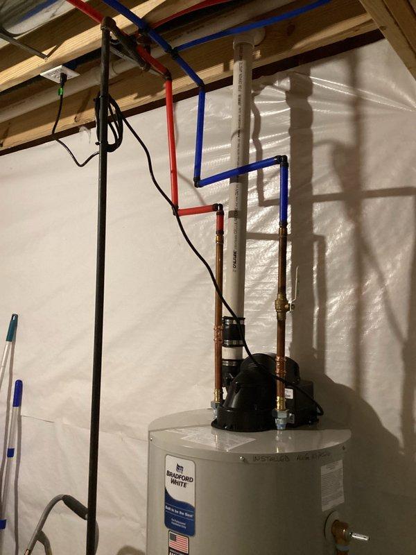 Installed a 50-gallon Bradford White natural gas automatic storage water heater with 40,000 BTU/hr input rating in basement utility area. Completed all necessary plumbing connections including PEX supply lines, copper piping, pressure relief valve installation, and proper venting with PVC discharge pipe routed through ceiling joists, ensuring all connections meet code requirements and manufacturer specifications.