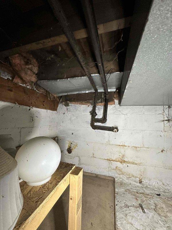 Responded to reported gas leak concern at residential property. Conducted comprehensive inspection of gas piping system including exterior foundation area and basement utility space. Examined gas line penetrations through foundation wall and inspected visible piping runs along ceiling joists and wall-mounted installations. Assessed PVC conduit installations and gray pipe routing at exterior foundation level. Evaluated basement gas distribution system including connections near storage tank area. Inspected pipe supports, joints, and penetration points for signs of compromise or active leakage. Documented conditions with photographic evidence showing pipe installations, foundation penetrations, and basement piping configurations. No active gas leak detected during inspection using standard leak detection procedures. Provided findings and recommendations to property owner regarding system integrity and safety status.