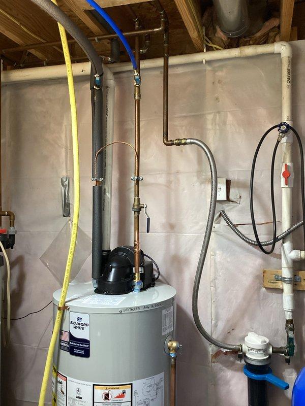 Installed Bradford White 50-gallon natural gas water heater (Model MCW50S6BN) in residential basement with recently finished living space. Completed all necessary plumbing connections using copper piping, brass fittings, and dielectric unions to prevent galvanic corrosion, and connected natural gas supply line with appropriate shut-off valves. Installation included proper venting, temperature and pressure relief valve with discharge piping, and code-compliant clearances in finished basement environment, with tarps used throughout to protect new flooring and surfaces.