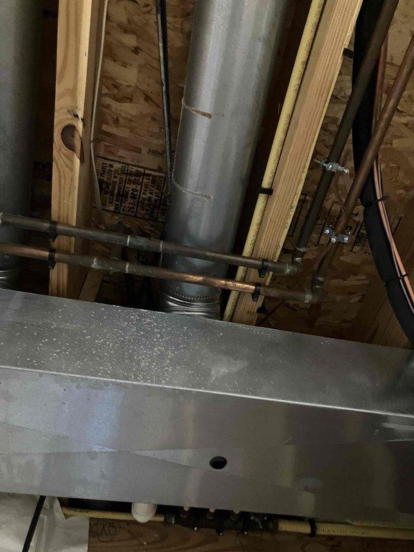 Conducted comprehensive assessment of residential HVAC system following water intrusion event that compromised both gas furnace and air conditioning equipment. Water infiltrated through AC vents, traveled to the gas furnace in the basement, and accumulated in ductwork connected to bathroom and laundry areas, causing structural damage to system components over time. Following completion of water restoration and mold remediation by specialized contractors, performed detailed inspection of affected HVAC infrastructure including furnace unit, air handler, ductwork, and outdoor condenser unit. Documented existing conditions through photographic evidence showing galvanized ductwork, metal plenum panels, and outdoor AC unit positioned on gravel pad against building exterior. Prepared itemized estimate documentation for insurance claim purposes detailing full system replacement requirements for both gas furnace and connected air conditioning equipment due to extent of water damage and contamin
