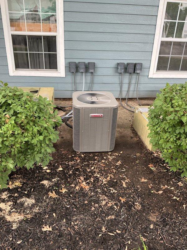 Completed installation of Lennox ML13KC1-024 air conditioning system with matching ADP evaporator coil. The outdoor condensing unit was positioned on a prepared pad against the exterior wall with proper clearances maintained from surrounding vegetation, and the evaporator coil was integrated with the existing Slant/Fin furnace system in the basement utility area. All refrigerant lines, electrical connections, and ductwork transitions were properly installed and sealed to ensure optimal system performance.