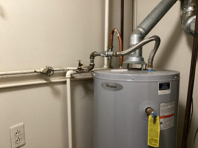 Responded to no hot water complaint at residential property. Upon arrival, inspected Whirlpool tanked water heater installation in utility room. Assessed unit condition, verified all plumbing connections including water supply lines, gas line with flexible connector, and PVC vent piping. Checked gas shut-off valve operation and examined control panel settings. Tagged unit for service and documented existing installation configuration including all safety components and manufacturer specifications for future reference.