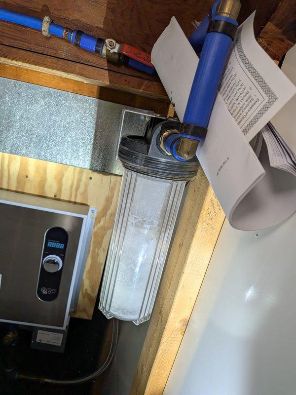 Responded to kitchen sink clogged and backing up into the basin. Customer reported chemicals had been used several days prior without success. Confirmed issue was isolated to single fixture with no gurgling in toilets or backup into other drains. Performed diagnostic assessment of kitchen drain line to determine blockage location and severity. Documented existing plumbing configuration including tankless water heater and water filtration system installation for service records.
