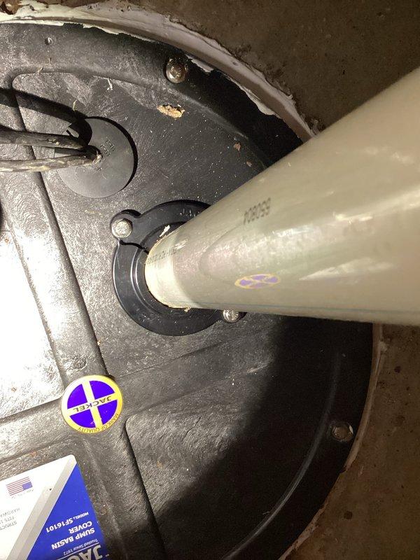 Responded to complaint of intermittent sewage odor in upstairs bathroom occurring when basement shower was in use. Inspected sump pump system and drainage connections in basement utility area. Found sump pump installation with PVC discharge piping and check valve assembly. Examined pump housing, discharge connections, and verified proper sealing of sump pit lid to prevent sewer gas escape. Documented existing equipment condition including pump assembly, electrical connections, and plumbing tie-ins. Advised on potential drain trap issues and venting concerns that could allow sewer gases to migrate between floors during water usage events.