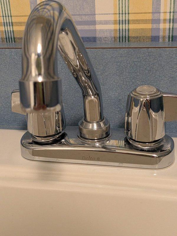 Responded to service call for three leaking faucets in the residence. Inspected and serviced two Delta brand faucets—one two-handle chrome faucet on beige countertop with integrated basin in bathroom, and one two-handle chrome faucet on white sink. Diagnosed worn internal components causing leaks, replaced cartridges and seals on all three faucet assemblies, and tested for proper operation and complete leak elimination.