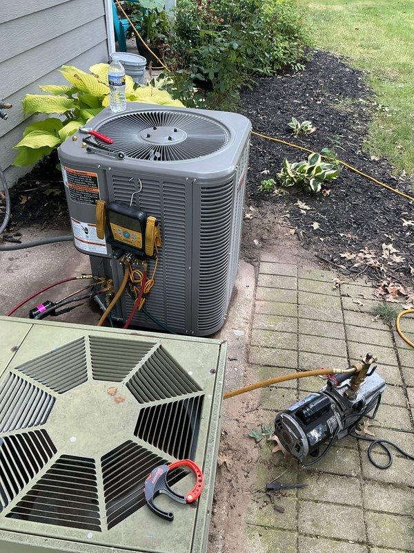 Completed installation of new outdoor air conditioning condenser unit on existing concrete paver pad in residential backyard. Unit was positioned, leveled, and secured with all refrigerant lines connected using proper copper piping and brass fittings. System was evacuated using vacuum pump to remove moisture and contaminants from refrigerant lines, then charged with appropriate refrigerant according to manufacturer specifications. All electrical connections were completed and verified. System startup procedures were performed with diagnostic equipment monitoring temperatures, pressures, and overall performance to ensure proper operation within manufacturer parameters.