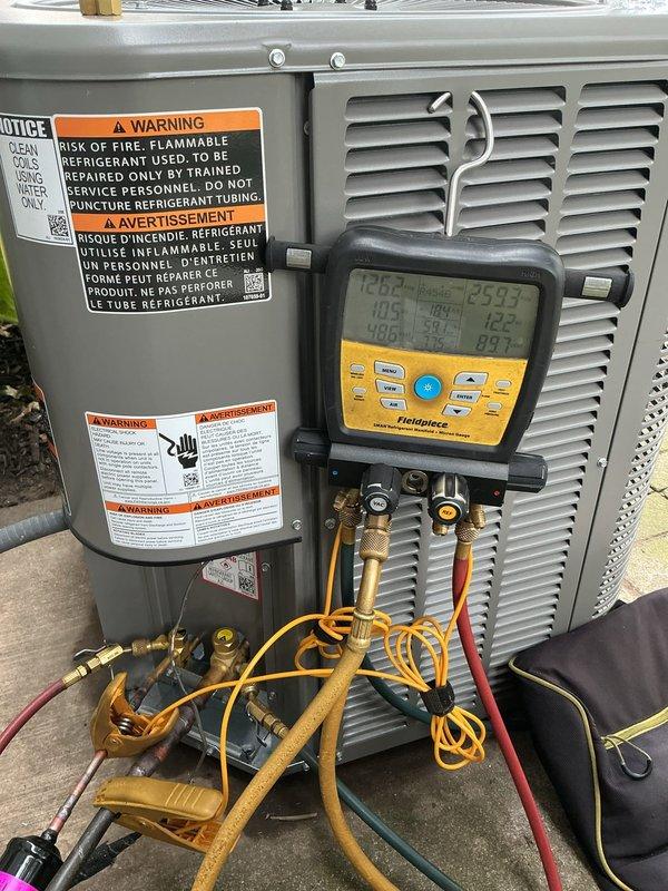 Completed installation of new outdoor air conditioning condenser unit on existing concrete paver pad in residential backyard. Unit was positioned, leveled, and secured with all refrigerant lines connected using proper copper piping and brass fittings. System was evacuated using vacuum pump to remove moisture and contaminants from refrigerant lines, then charged with appropriate refrigerant according to manufacturer specifications. All electrical connections were completed and verified. System startup procedures were performed with diagnostic equipment monitoring temperatures, pressures, and overall performance to ensure proper operation within manufacturer parameters.