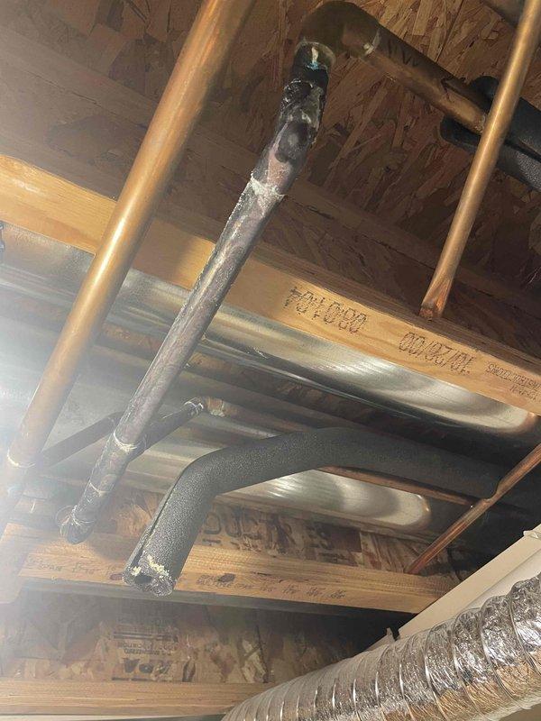 Responded to basement water leak from small copper pipe. Upon arrival, water was not shut off and slow drip had created standing water. Inspected HVAC and plumbing infrastructure in basement ceiling area, identifying leak source at copper pipe connection near ductwork. Documented existing conditions including mineral deposits on adjacent piping and overall system configuration. Assessed leak severity, surrounding piping condition, and recommended repair approach to address the active leak and prevent further water accumulation.
