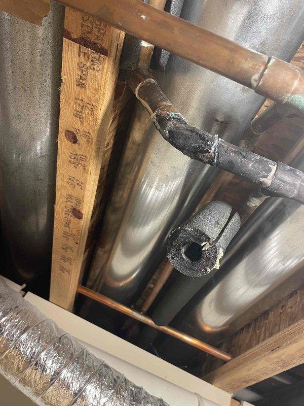 Responded to basement water leak from small copper pipe. Upon arrival, water was not shut off and slow drip had created standing water. Inspected HVAC and plumbing infrastructure in basement ceiling area, identifying leak source at copper pipe connection near ductwork. Documented existing conditions including mineral deposits on adjacent piping and overall system configuration. Assessed leak severity, surrounding piping condition, and recommended repair approach to address the active leak and prevent further water accumulation.