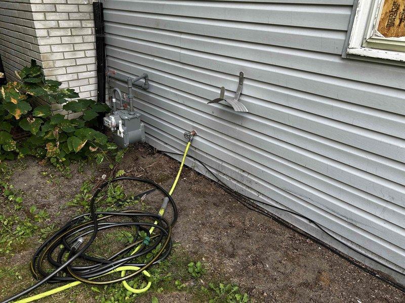 Provided comprehensive plumbing estimate for residential property including interior water line connections, dishwasher drainage installation, and exterior hose bibb replacement. Assessed existing plumbing infrastructure at exterior wall penetrations and interior bathroom fixtures to determine scope of work for complete water supply hookup and drainage system modifications.