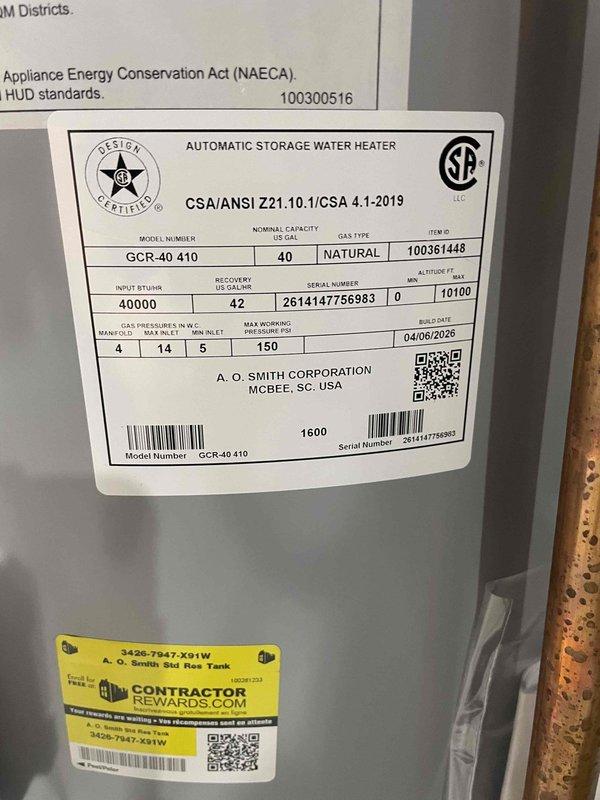 Completed installation of 40-gallon A.O. Smith natural gas water heater (Model GCR-40 410) in basement utility area. Unit was properly positioned on concrete floor, connected to existing copper supply lines and overhead plumbing systems, and integrated with HVAC infrastructure in residential setting.