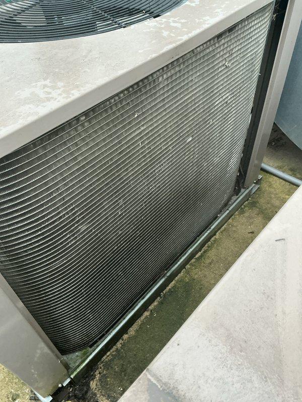 Responded to no-cooling complaint on residential air conditioning system approximately 10 years old with airflow present but warm air discharge. Upon inspection, discovered severely contaminated condenser coils with heavy accumulation of dirt, dust, and debris restricting airflow and heat transfer capability. Thoroughly cleaned condenser coil fins to restore proper heat exchange function and system efficiency. System tested and verified returning to normal cooling operation following coil cleaning procedure.