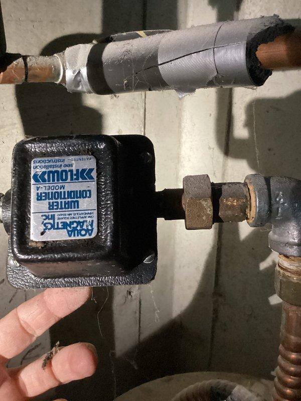Responded to service call for 5-year-old tanked water heater reported as non-operational with strange odor and no visible leaks. Upon arrival, performed diagnostic inspection of water heater system and associated plumbing infrastructure. Evaluated copper supply lines with insulation, brass compression fittings, and connections. Inspected water treatment system including expansion tanks, PEX distribution lines, and whole-house filtration assembly mounted on wall. Examined control device and monitoring equipment connected to the system. Assessed all visible components including pressure vessels, brass fittings, and blue PEX tubing connections. Documented existing conditions with photographic evidence showing plumbing configuration, filtration hardware, and mechanical room setup for diagnostic purposes and future reference.