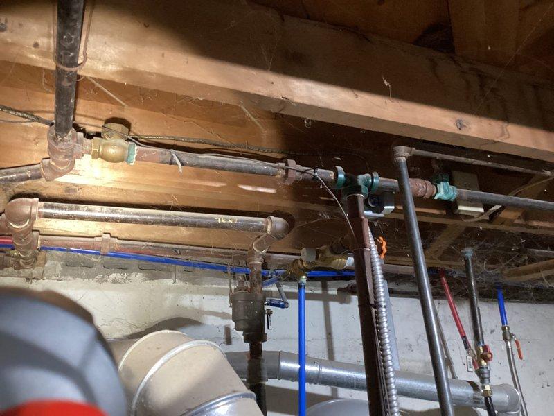 # HVAC Maintenance Summary

Completed routine preventive maintenance inspection on residential HVAC system. All operational parameters verified within normal specifications with no deficiencies identified. System operating efficiently with no service requirements at this time.

# Detailed Work Performed

Performed comprehensive planned maintenance service on residential HVAC equipment. Conducted thorough visual inspection of accessible system components and infrastructure. Documented existing plumbing and mechanical installations in basement/crawl space area for service records.

Inspected exposed piping infrastructure including copper supply lines, PEX distribution piping, and associated valve assemblies. Observed multiple shut-off valves with age-appropriate patina and oxidation on brass/bronze fittings. Noted presence of flexible metal conduit, various pipe mounting hardware, and properly secured blue PEX tubing runs along floor joists.

Examined structural mounting of plumbing comp