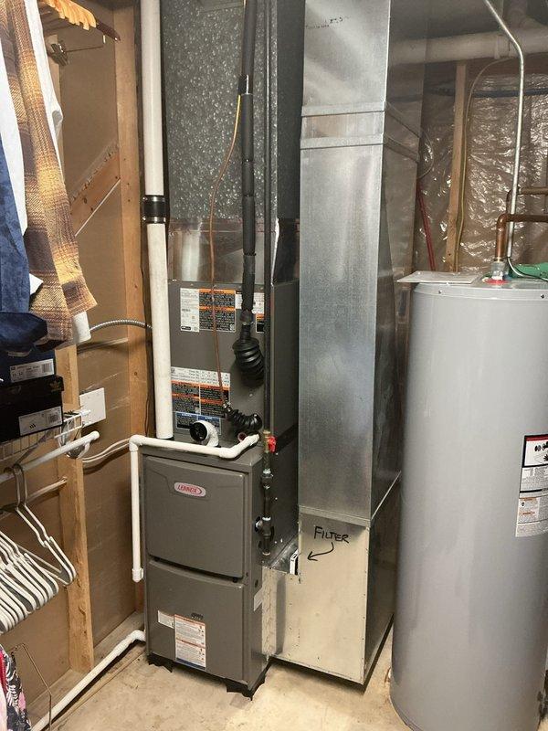 Completed full HVAC system installation including new Lennox furnace, air conditioning condenser unit, and thermostat. Installed furnace in basement mechanical room with proper PVC condensate drainage and venting, connected to existing ductwork and plenum system. Positioned outdoor condenser unit on concrete pad adjacent to property fence, ran refrigerant lines to interior equipment, and completed all electrical connections. Reused existing air cleaner as specified. System tested and operational upon completion.