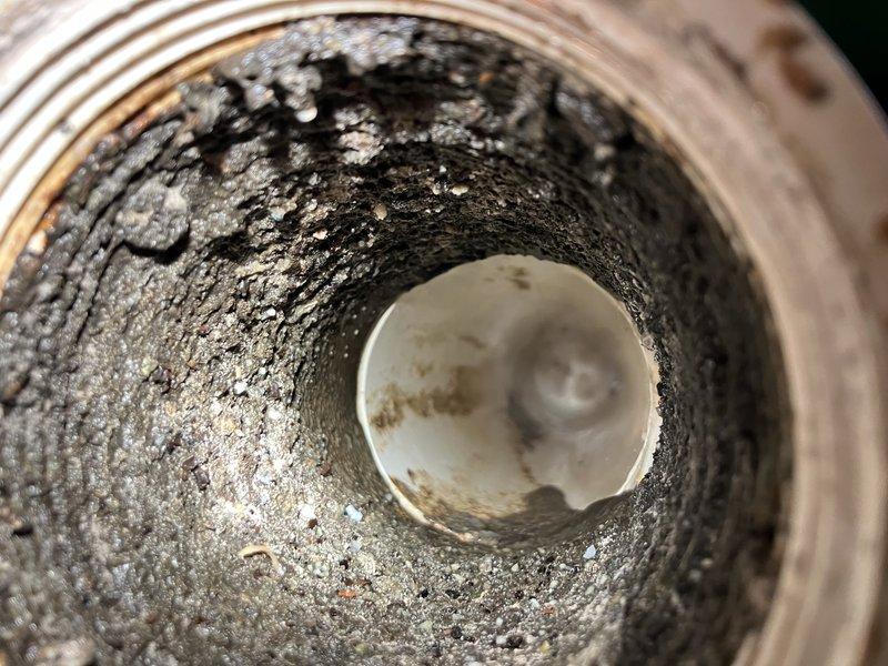Responded to service call for outdoor spigot inspection and kitchen sink drainage issue at rear of property. Upon assessment, replaced malfunctioning outdoor spigot due to internal component failure. Addressed kitchen sink slow drain condition caused by significant buildup and blockage in drain line, as evidenced by heavy accumulation of debris and crystallized material coating interior pipe walls. Cleared obstruction and restored proper drainage function to kitchen sink system.