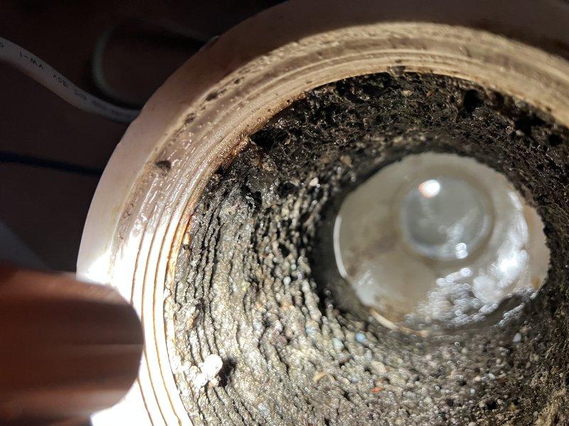 Responded to service call for outdoor spigot inspection and kitchen sink drainage issue at rear of property. Upon assessment, replaced malfunctioning outdoor spigot due to internal component failure. Addressed kitchen sink slow drain condition caused by significant buildup and blockage in drain line, as evidenced by heavy accumulation of debris and crystallized material coating interior pipe walls. Cleared obstruction and restored proper drainage function to kitchen sink system.