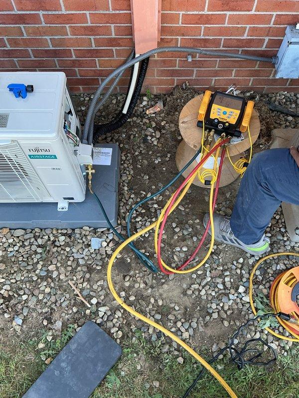 Installed Fujitsu Airstage mini-split system in room 107, including indoor wall-mounted air handler and outdoor condensing unit mounted on brick exterior. Completed full system startup, verified refrigerant charge using digital manifold gauges, and performed all operational checks to ensure proper system function and performance parameters were met.