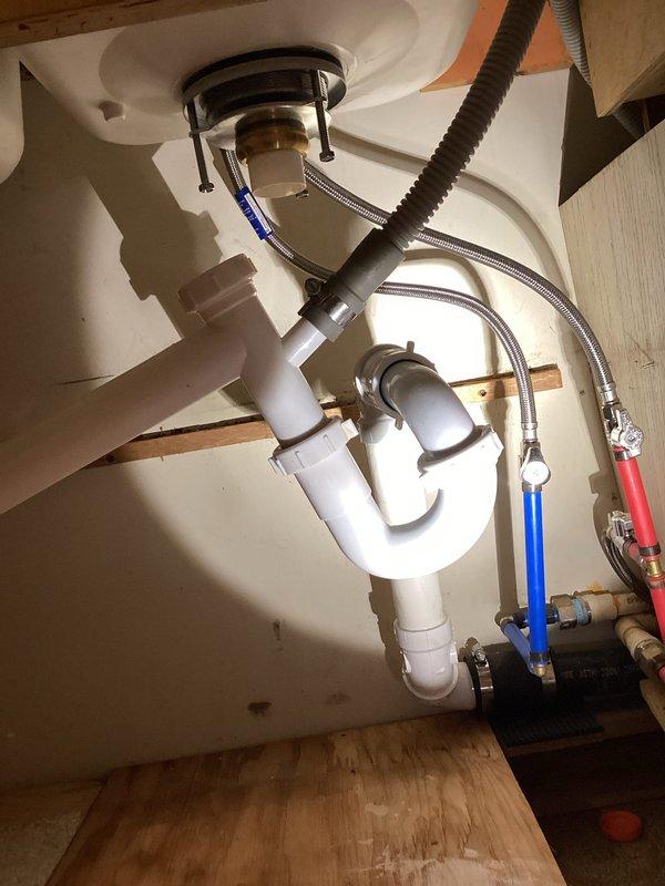Responded to service call regarding kitchen sink drain assembly that had separated from previous installation. Upon arrival, inspected under-sink plumbing connections and confirmed P-trap configuration had disconnected, causing wastewater to discharge into cabinet area below sink. Reassembled drain components, secured all slip-joint connections, and verified proper alignment of tailpiece, P-trap, and drain extension. Tested system by running water through sink to confirm proper drainage flow and verify all connections were sealed without leakage. Inspected surrounding plumbing infrastructure including water supply lines and shut-off valves to ensure no additional issues were present.