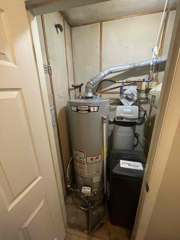 Completed full installation of A.O. Smith residential tanked water heater in utility closet per quoted specifications. Unit was properly positioned, connected to existing copper supply lines, and integrated with adjacent water treatment system. All plumbing connections were secured, system was tested for proper operation, and installation met code requirements.