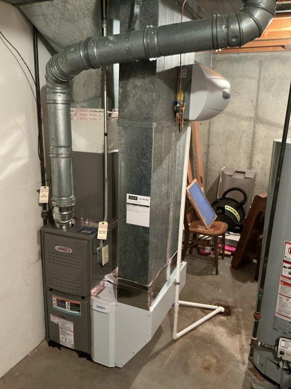 Completed full HVAC system installation in residential basement, including new Lennox furnace and air handler with integrated ductwork. Installed AprilAire whole-house humidifier with copper water supply line and metal duct collar adapter, connected to main system via galvanized metal ductwork. All refrigerant lines, electrical connections, and ventilation components properly installed and secured to meet manufacturer specifications and code requirements.