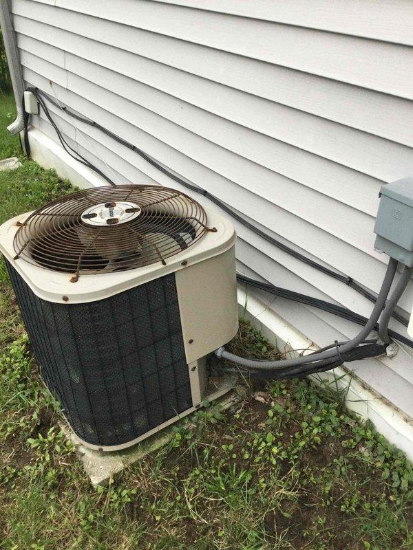 Performed comprehensive evaluation of 26-year-old HVAC system for replacement estimate. Conducted multi-point safety inspection including CO detection, gas leak check, and electrical system assessment on operational furnace and air conditioning equipment. Documented existing gray metal furnace unit in basement mechanical room with white PVC venting system and outdoor tan/beige cylindrical condenser unit with black protective grille mounted on concrete pad against exterior wall. System confirmed operational and ready for replacement quote preparation.
