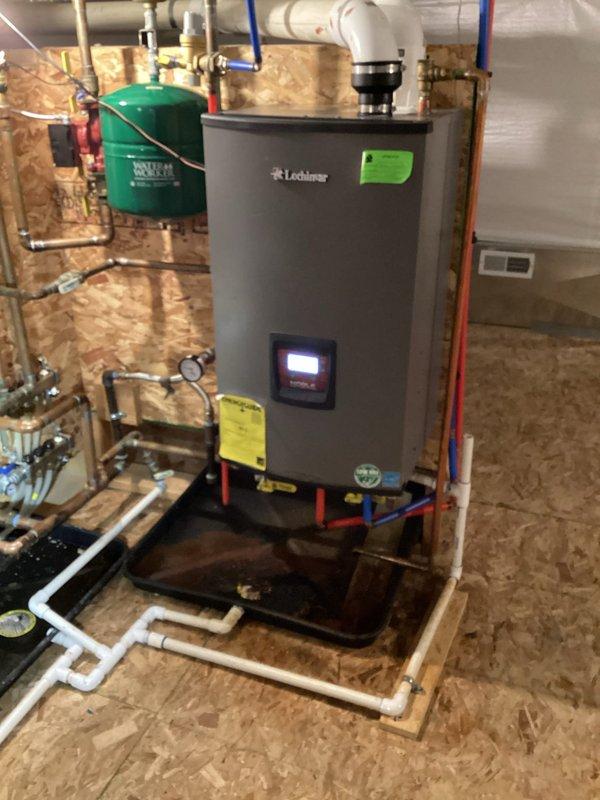 Completed planned trio maintenance on Navien NPE-180A tankless water heater system installed in pole barn structure. Performed comprehensive inspection of unit, verified proper operation of digital display and controls, checked all plumbing connections including copper supply lines and PVC venting, inspected expansion tank and associated valves, and documented equipment condition through photographic records. All system components found operating within normal parameters.