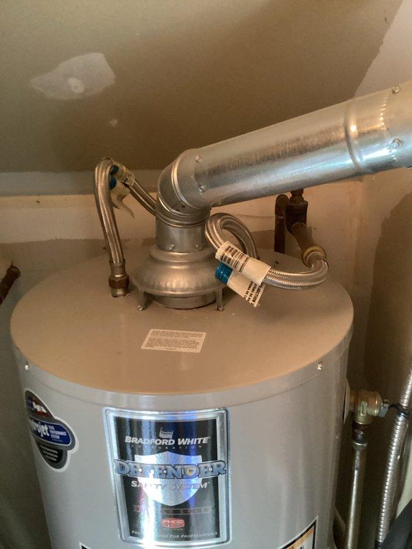 Responded to service call for 10-year-old Bradford White 40-gallon residential gas water heater with no hot water production. Customer reported pilot light would not reignite after following standard relighting procedures. Upon arrival, performed diagnostic inspection of unit including examination of gas control valve, thermocouple, pilot assembly, and burner components. Verified gas supply to unit and checked for proper venting through exhaust flue system. Inspected flexible water supply connections and confirmed no visible leaks present at tank or connections. Documented existing installation configuration including braided stainless steel supply lines and proper venting arrangement with metallic exhaust pipe. Unit equipped with standard safety features and manufacturer labeling intact showing capacity specifications and safety warnings. Assessed overall condition of water heater installation in residential utility area.