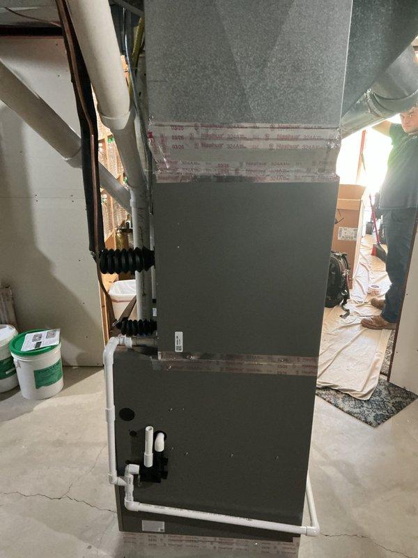 Completed full HVAC system installation in basement utility area, including EL297 furnace and EL18 air conditioning unit with new refrigerant line set. Installed S40 smart thermostat with touchscreen interface and integrated 1620 whole-home air cleaner into the system. All equipment mounted on raised platform, PVC condensate drainage lines properly routed, and flexible ductwork connections secured to ensure optimal airflow and system performance.