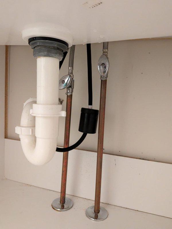 Responded to service call for leaking laundry tub faucet at base. Removed and disposed of old faucet assembly, then installed customer-supplied chrome pull-down faucet with gooseneck spout. Connected hot and cold water supply lines using braided flexible hoses, secured all connections, and tested for proper operation and leaks. System functioning properly upon completion.
