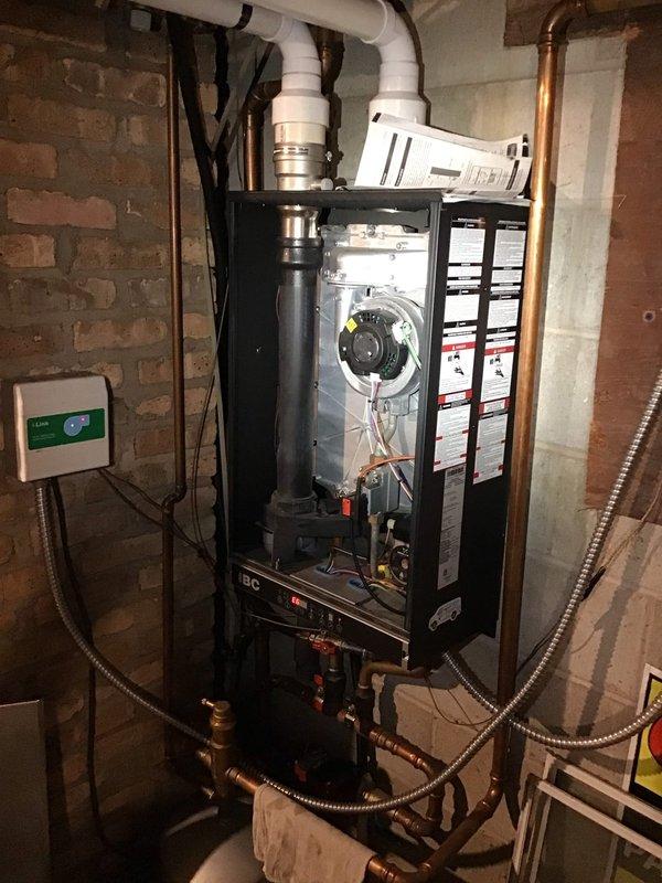 Provided comprehensive quote for new boiler system replacement at customer's request. Evaluated existing tankless water heater installation with wall-mounted unit, PVC venting, copper supply lines with shut-off valves, and Honeywell digital thermostat currently set at 76 degrees. Documented equipment configuration including internal blower assembly, flexible conduit connections, and control panel setup. Photographed complete system for quote preparation. Recommended Gold Level service agreement covering one system with annual maintenance visits, noting system is due for renewal.