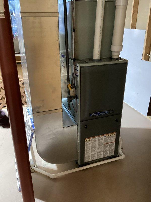 Completed annual preventative maintenance inspection on American Standard residential furnace system. Performed comprehensive system evaluation including visual inspection of all accessible components, burner assembly, heat exchanger, blower motor, and venting system. Verified proper operation of safety controls and limit switches. Inspected both white PVC intake and exhaust vent pipes for proper installation and clearances. Removed and evaluated existing air filter, which showed normal dust accumulation consistent with regular use. Replaced air filter with new unit to ensure optimal airflow and system efficiency. Confirmed furnace mounted securely on drain pan with proper clearances maintained. All components found operating within manufacturer specifications with no deficiencies noted. System tested and left in proper working condition.