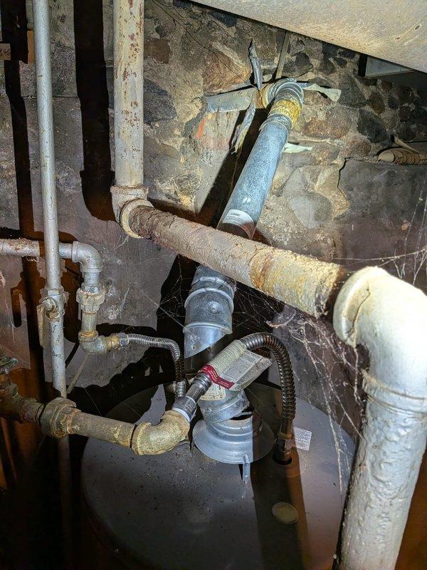 Responded to no heat call on 12-year-old furnace system. Upon arrival, confirmed no heat output and no airflow through vents. Performed diagnostic inspection of heating system and associated components in mechanical room. Visually inspected furnace cabinet, control board, gas valve, and ignition system. Checked electrical connections, circuit breakers, and thermostat wiring for continuity and proper voltage. Examined condensate drain lines and pressure switches for blockages or failures. Inspected heat exchanger for cracks or deterioration given age of unit. Tested blower motor operation and capacitor functionality. Verified gas supply line pressure and valve operation. Documented existing corrosion on nearby plumbing infrastructure and overall age-related wear on mechanical systems. Provided findings and repair recommendations to restore heating operation.