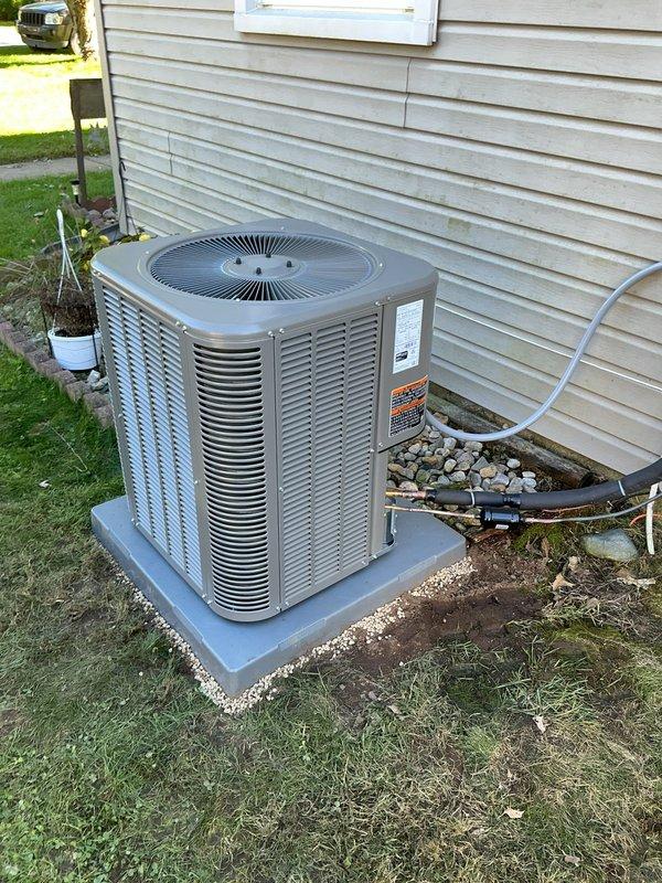 Completed full HVAC system installation including ML180UH070E36A furnace, ML13KC1-024 condenser unit, CK40CT-24A evaporator coil, and S200 thermostat. Positioned outdoor condensing unit on concrete pad with proper clearances from structure, installed electrical disconnect box and conduit routing to exterior wall, and ran refrigerant lines and drain piping from condenser to indoor air handler. Set up gravel base around outdoor unit for drainage and aesthetic finish, verified all electrical connections meet code requirements, and confirmed proper system operation with new digital thermostat control.