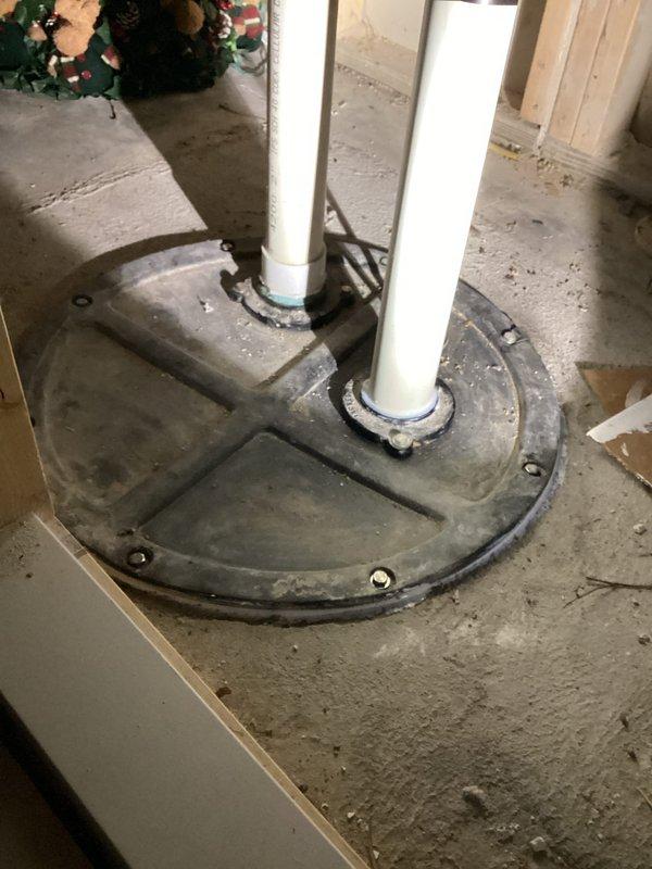 Responded to service call for non-operational sewage pump serving basement bathroom. Upon arrival, accessed pump location in under-stair utility space and confirmed pump failure with no power to unit despite no tripped breakers. Inspected dual-pipe sewage ejector system with floor-mounted rubber boot assembly and determined pump required replacement to restore functionality to basement plumbing fixtures.