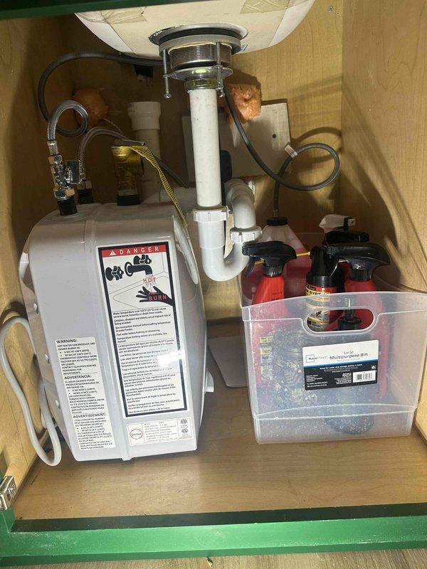Conducted site assessment for three-compartment commercial sink installation with grease trap integration. Evaluated existing plumbing infrastructure including current drain lines, P-trap configuration, and crawl space drainage system to determine feasibility of connecting new fixtures without concrete floor penetration. Photographed and documented existing under-sink plumbing with garbage disposal, PVC drain assembly, and accessible drain lines in crawl space. Provided estimate for elevated sink and grease trap installation utilizing extended legs and mounting stand to achieve proper height differential for gravity drainage into existing waste lines, eliminating need for floor core drilling.
